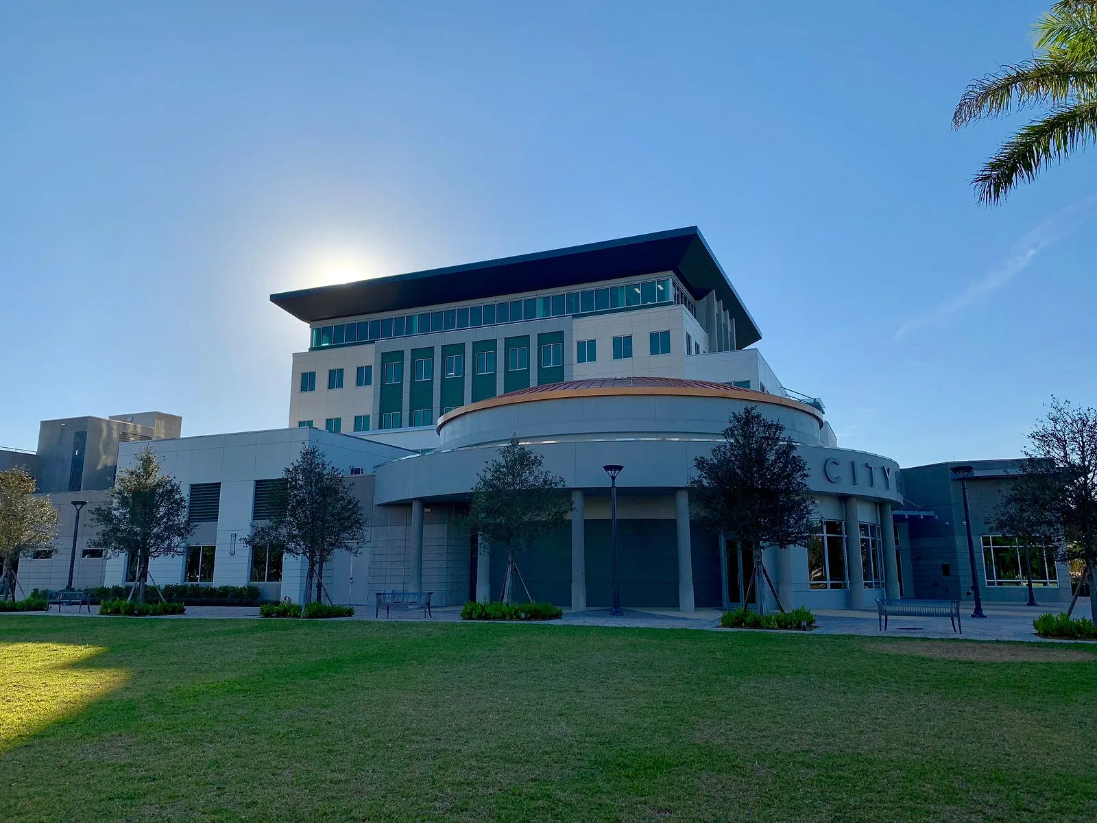 Coral Springs City Hall with a green lawn and young trees in front