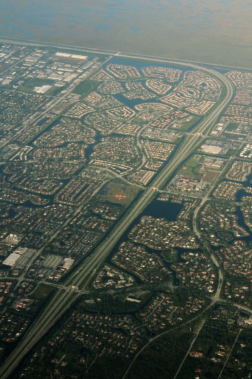 Aerial view of the Sawgrass Expressway curving between Coral Springs and Parkland neighborhoods